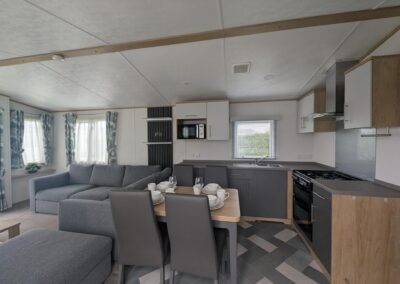 Carnaby Silverdale 2021 kitchen with modern cabinetry, integrated appliances and dining table